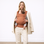 Parent carrying newborn in soft baby carrier — NAEVII