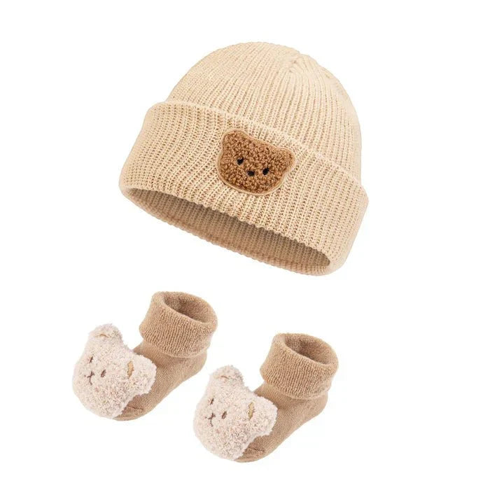 Cozy Bear plush toy beside a baby carrier — NAEVII